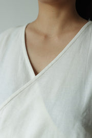 Close-up of V-neck detail of a sleeveless wrap top crafted from hemp and cotton, soft and lightweight for warm weather dressing