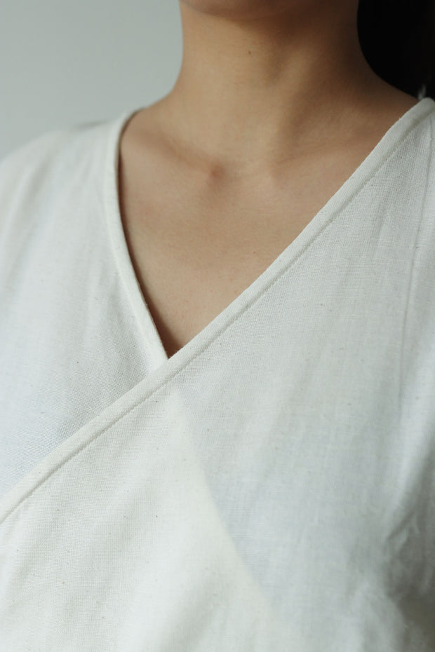 Close-up of V-neck detail of a sleeveless wrap top crafted from hemp and cotton, soft and lightweight for warm weather dressing