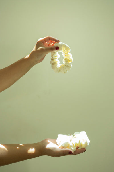 Hands holding an eco-friendly scrunchie made from surplus hemp/cotton fabric, highlighting sustainable fashion practices