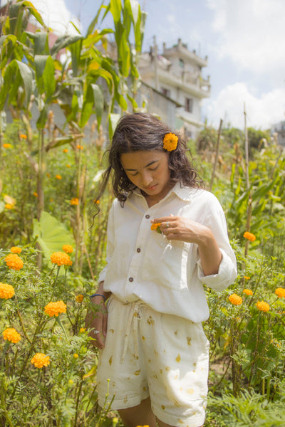 a woman wears a Naturally dyed hemp shorts that has marigold prints