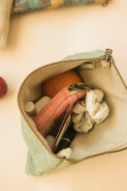 Open hemp pouch filled with natural toiletries and reusable essentials
