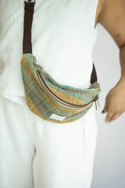 A vibrant striped hemp waist bag, sustainably crafted with multiple pockets and an adjustable strap for versatile wear.