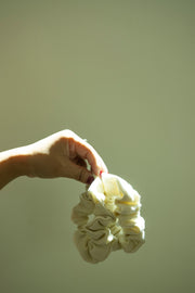 Hands holding an eco-friendly scrunchie made from surplus hemp/cotton fabric, highlighting sustainable fashion practices