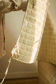 Natural hemp yoga mat draped over a chair, showing its flexibility.
