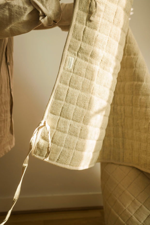 Natural hemp yoga mat draped over a chair, showing its flexibility.