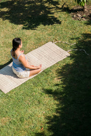 Woman meditating outdoors on the natural hemp yoga mat.