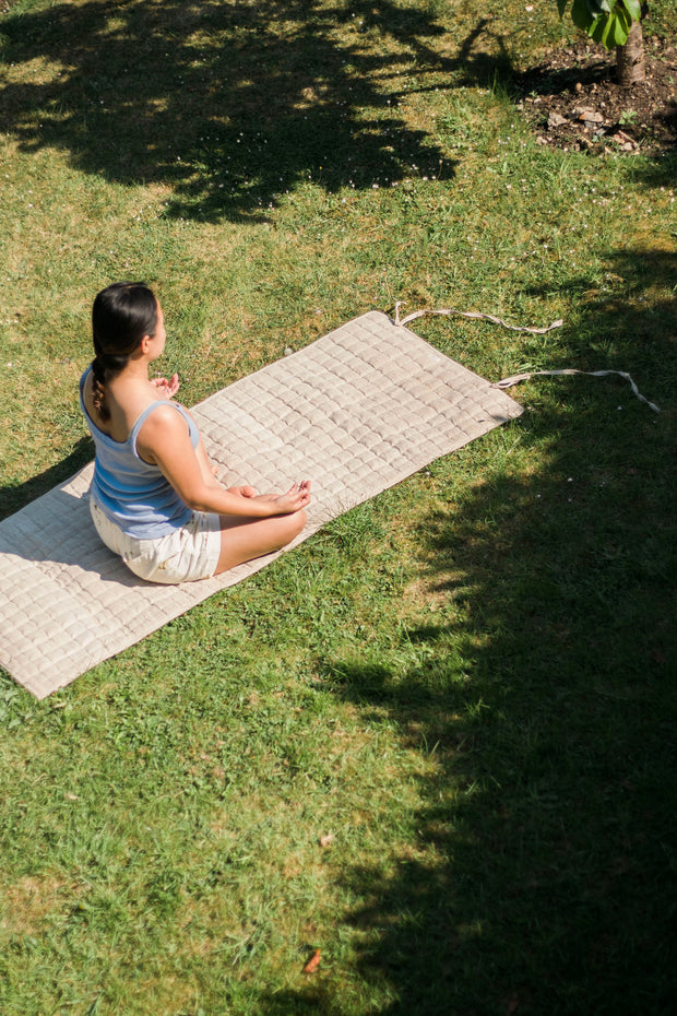 Woman meditating outdoors on the natural hemp yoga mat.