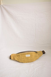 A bold mustard-colored hemp waist bag, featuring durable handcrafted design and ample storage space