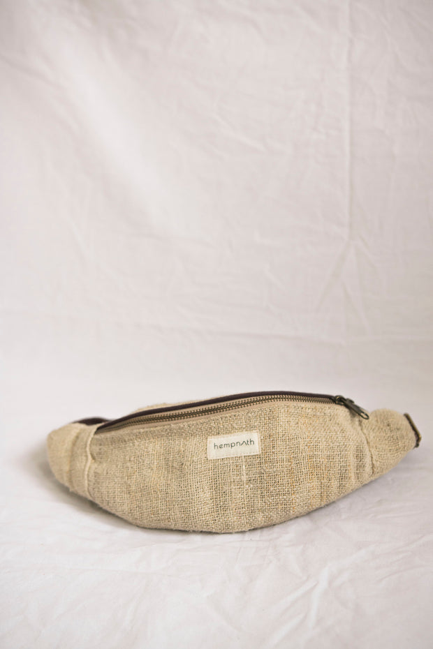 A stylish and eco-friendly hemp waist bag in a natural beige tone. Handcrafted with multiple compartments and an adjustable strap, perfect for carrying small essentials.